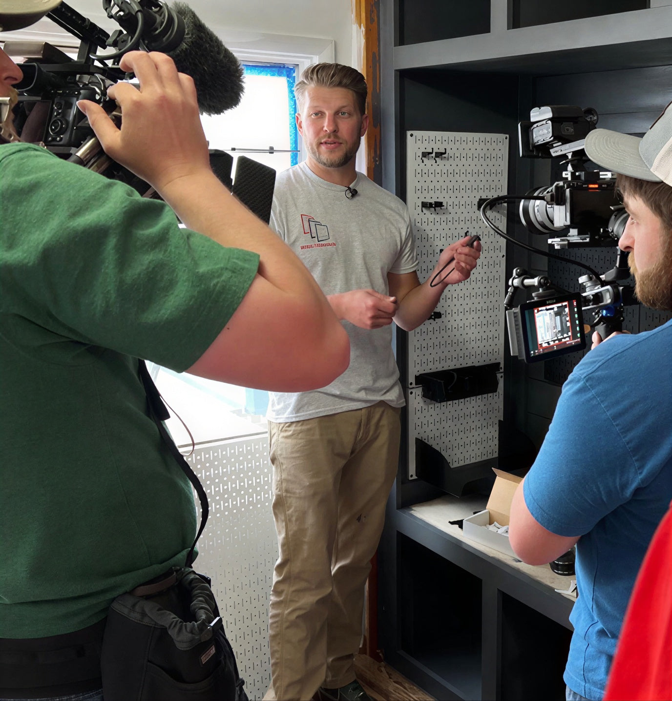 Wall Control employee being filmed by a camera crew in an indoor setting