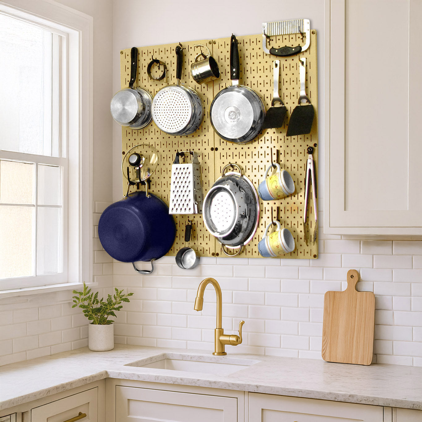 Wall Control gold pegboard kitchen wall organizer with black accessories used to store pots, pans, and cooking utensils above countertop.