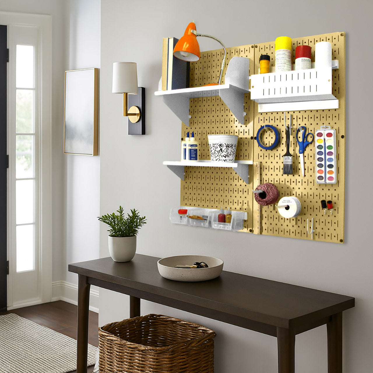 Wall Control gold pegboard wall organizer with white shelves and bins mounted in a craft room for art supplies and tools.