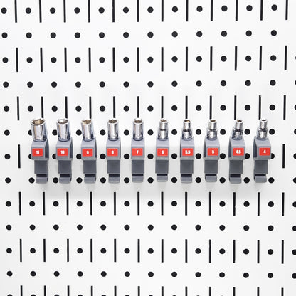 Set of TROPEK™ 101 Brackets holding multiple sockets in adjacent slots on a Wall Control™ panel.