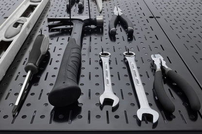 Close-up of tools arranged on a black Wall Control metal pegboard panel