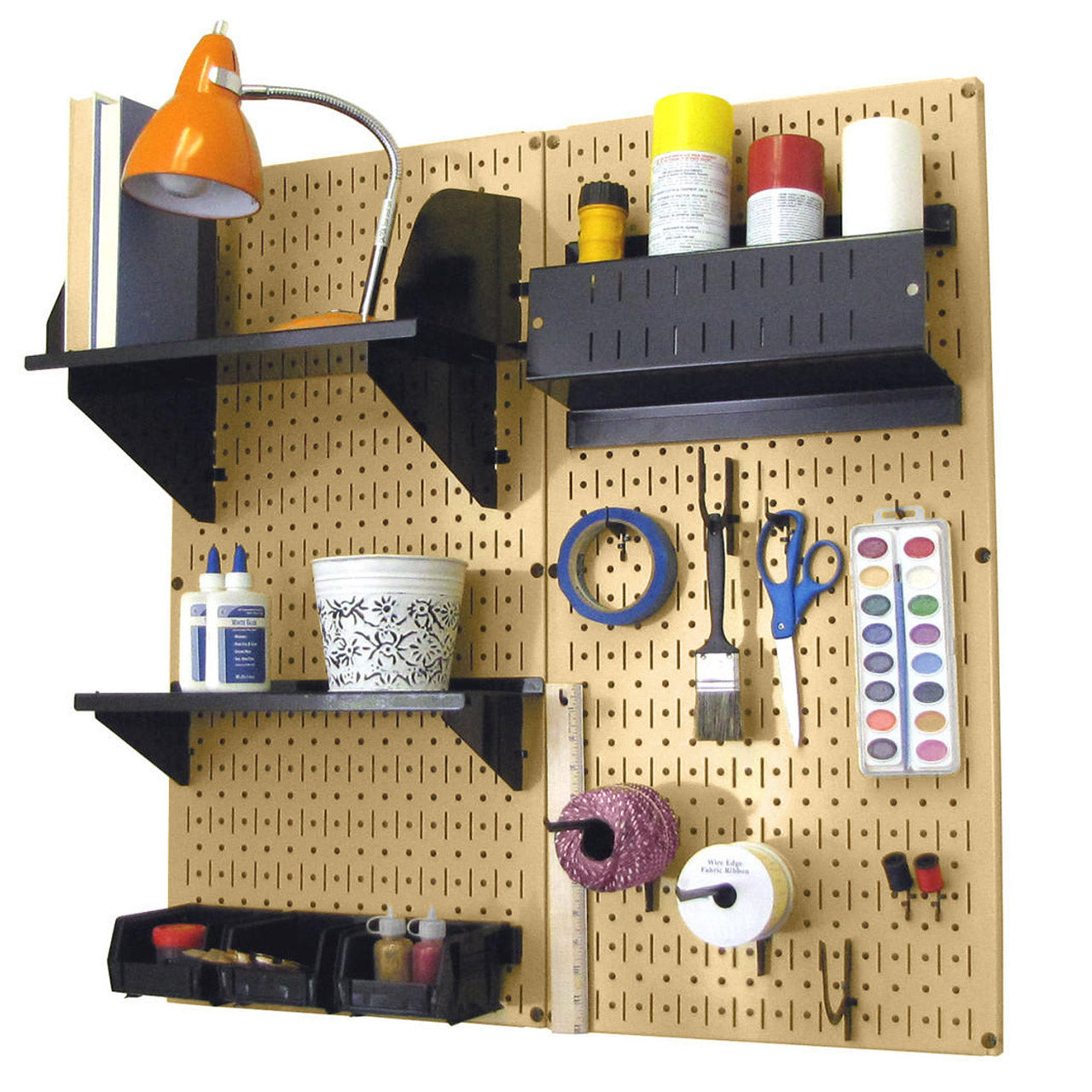 Wall Control gold pegboard wall organizer with black shelves and hooks holding craft supplies, paintbrushes, and art tools.